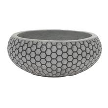 Šedý keramický kvetináč s hexagonálnym vzorom.