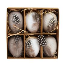 Sada plastových vajíčok s pierkami v krémovej farbe.