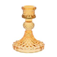 Sklenený svietnik v oranžovej farbe.