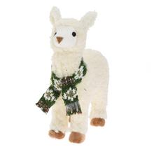 Stojaca biela alpaka so zeleným šálom.