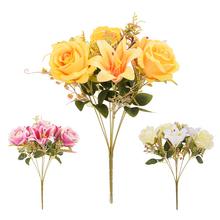 Kytica umelých kvetov s ružami a ľaliami v žltých a ružových odtieňoch.