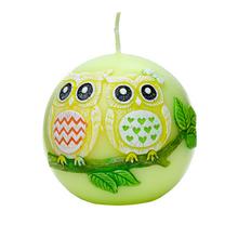 Sviečka v tvare guľatej sovy s farebnými detailmi.