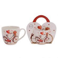 Šálka s motívom bicykla a srdiečok.